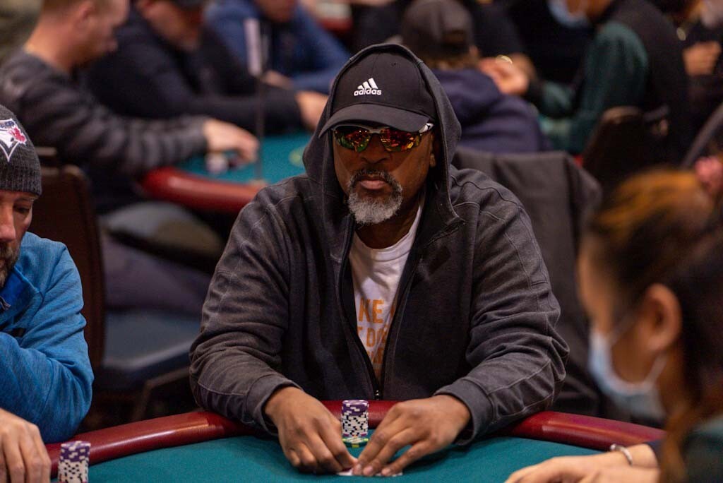 Poker players seated around a tournament table